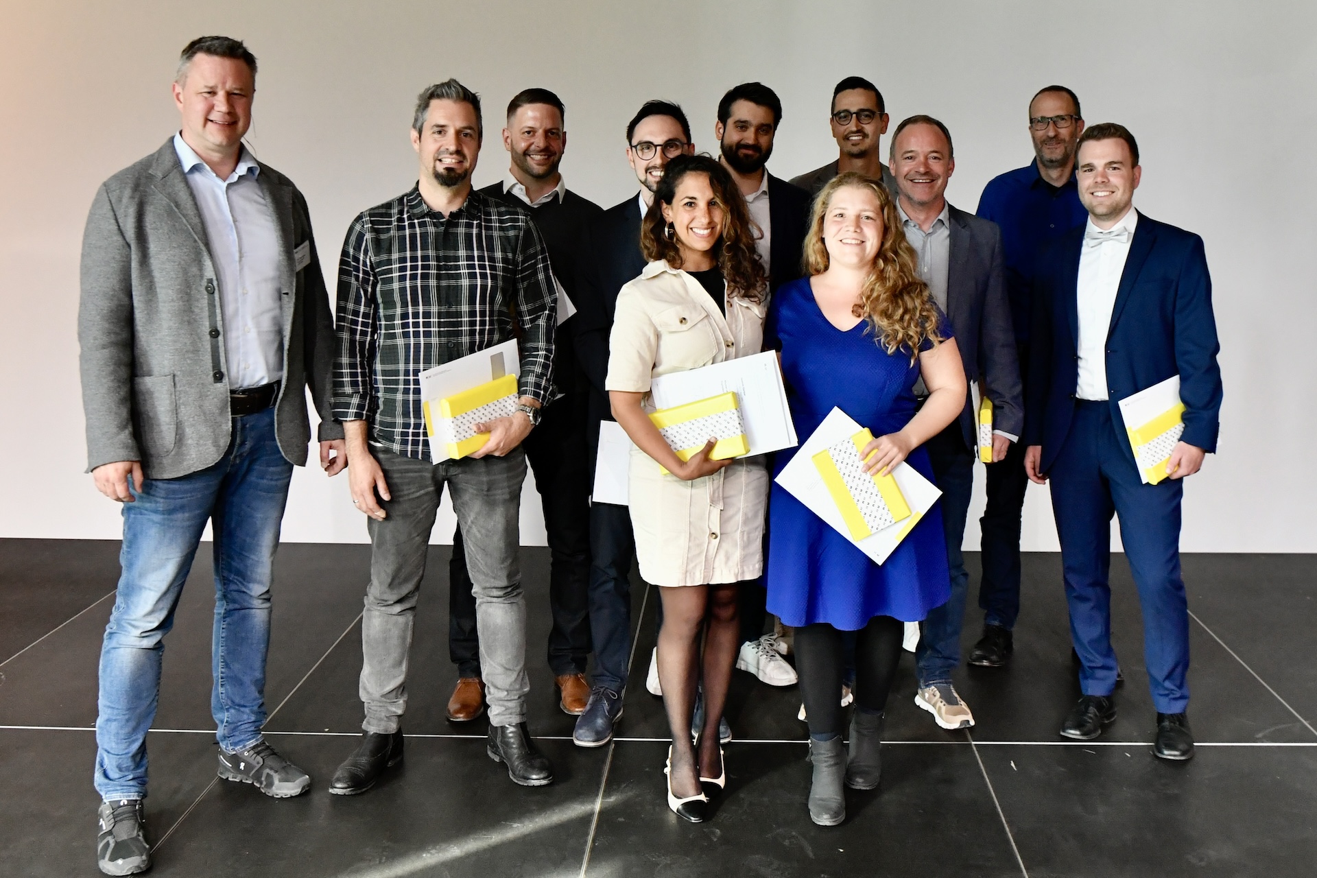 Gruppenbild von Diplomierten mit einem Zertifikat in der Hand