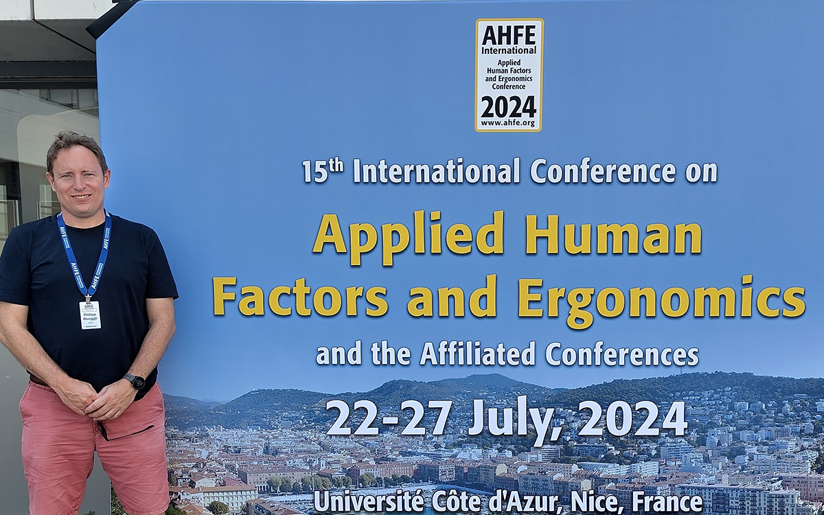 Philipp Renggli posiert vor dem Plakat des Best Paper Awards ind Nizza. 