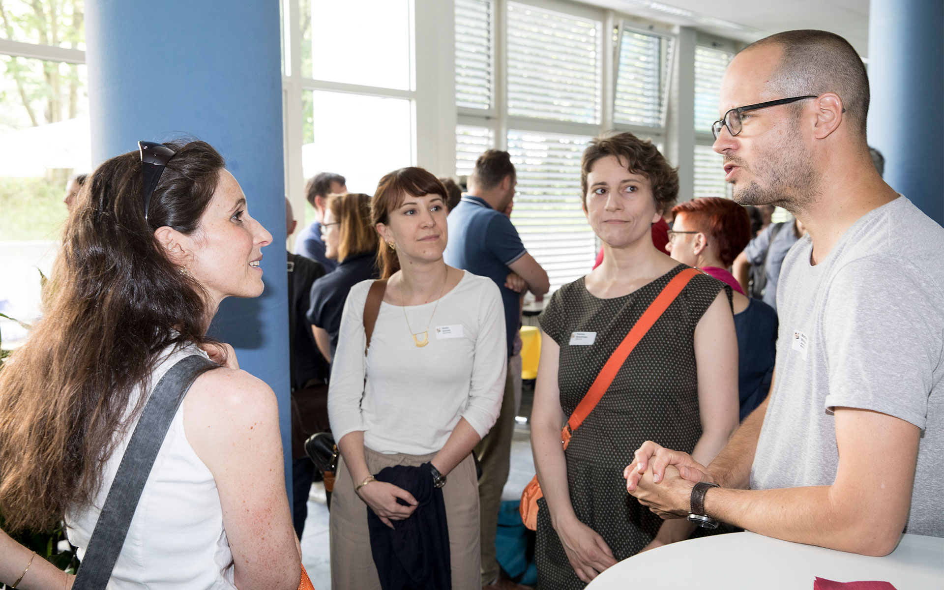 Einige Gäste der Jubiläumsfeier stehen im Halbkreis und diskutieren.