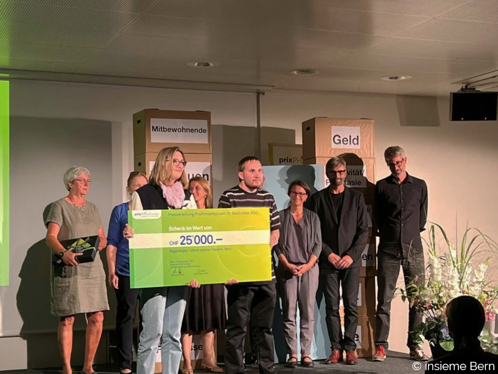 Auf einer Bühne wird der Preis entgegengenommen