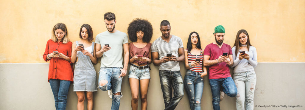 Jugendliche lehnen sich an eine Wand