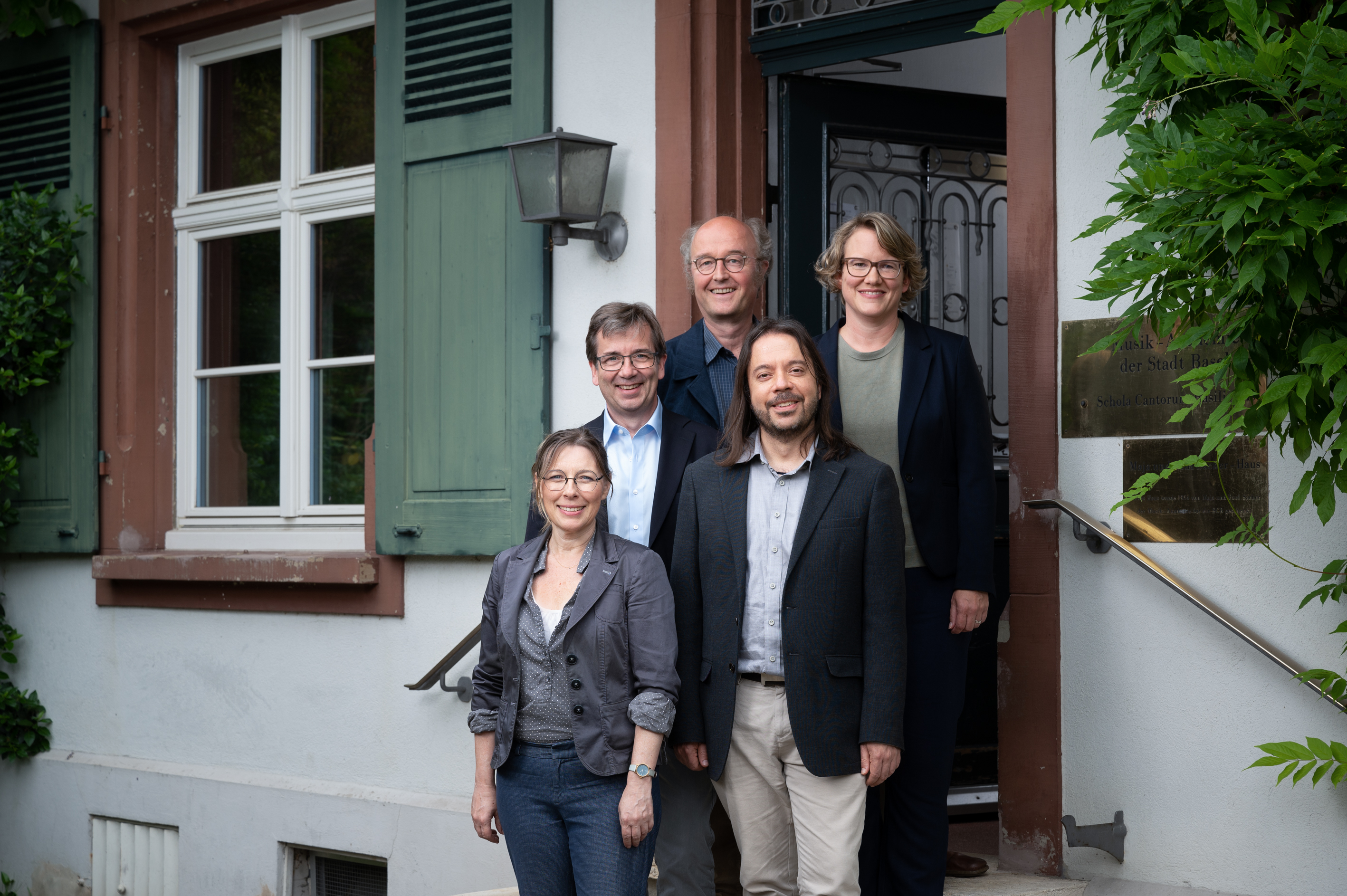 Foto des neuen Leitungsteams vor dem Eingang der Schola Cantorum in Basel, von links nach rechts: Kelly Landerkin, Christian Hilz, Martin Kirnbauer, C. Federico Sepúlveda, Brigitte Schaffner