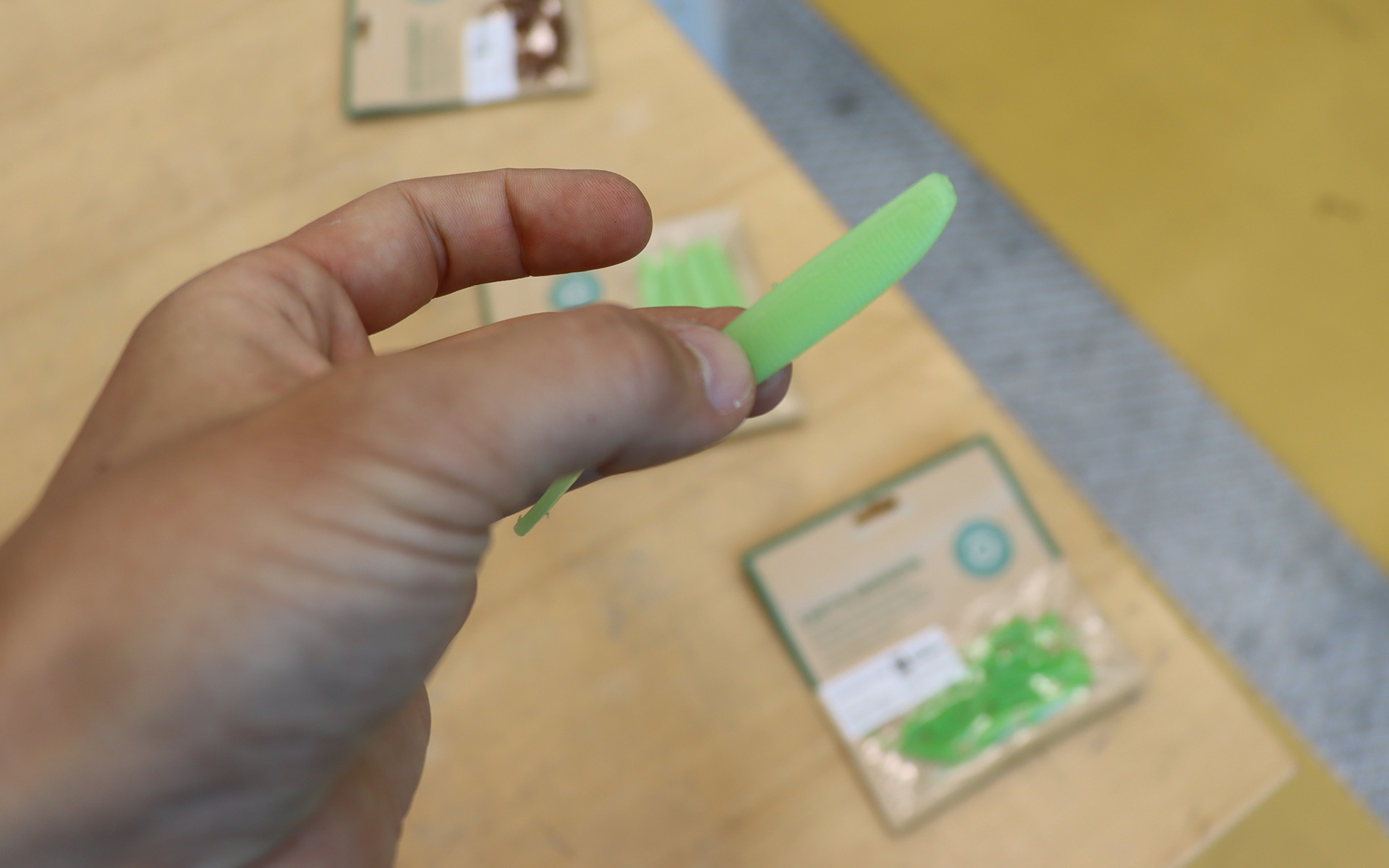 Eine Hand hält einen leuchtend grünen Angelköder von Capt'n Greenfin