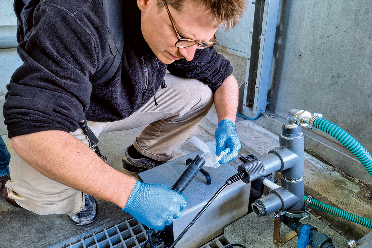 Der wissenschaftliche Mitarbeiter Bartosz Kawecki reinigt die in der Kläranlage Birs installierten Sensoren.