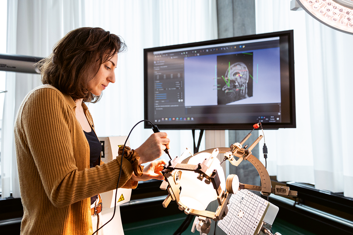 Céline Vergne testet ihr elektromagnetisches Navigationssystem zur Lokalisierung von Elektroden im Gehirn an einem Kopfphantom in einem stereotaktischen Headset.